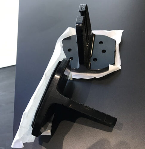 Two solar mounts with adhesive bottoms and paper backing sit on a table.