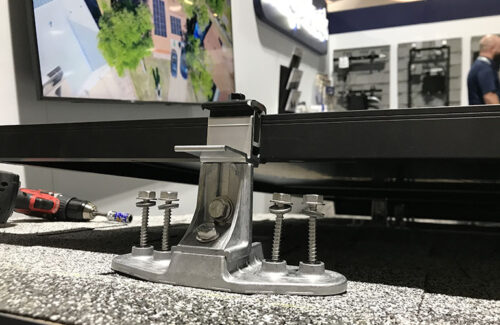 A solar mount attached to a panel on a mock rooftop.